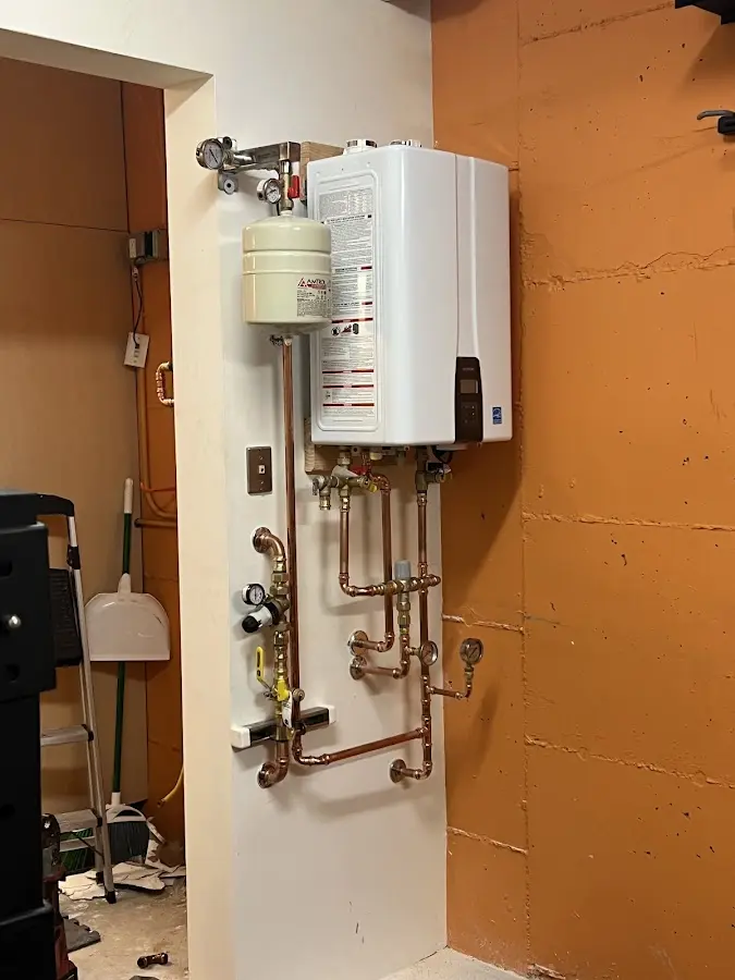 Plumbing technician inspecting water heater connections in Overlea